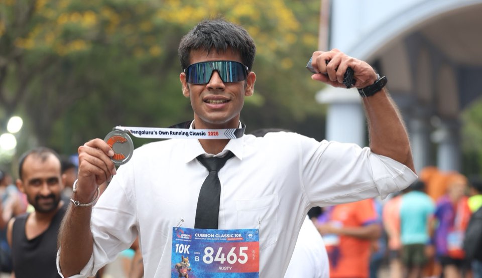 A finisher holding a Cubbon Classic medal